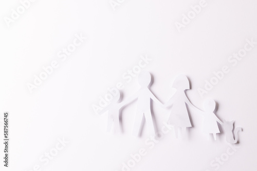 Fototapeta Naklejka Na Ścianę i Meble -  White paper cut out of family with two children and cat and copy space on white background
