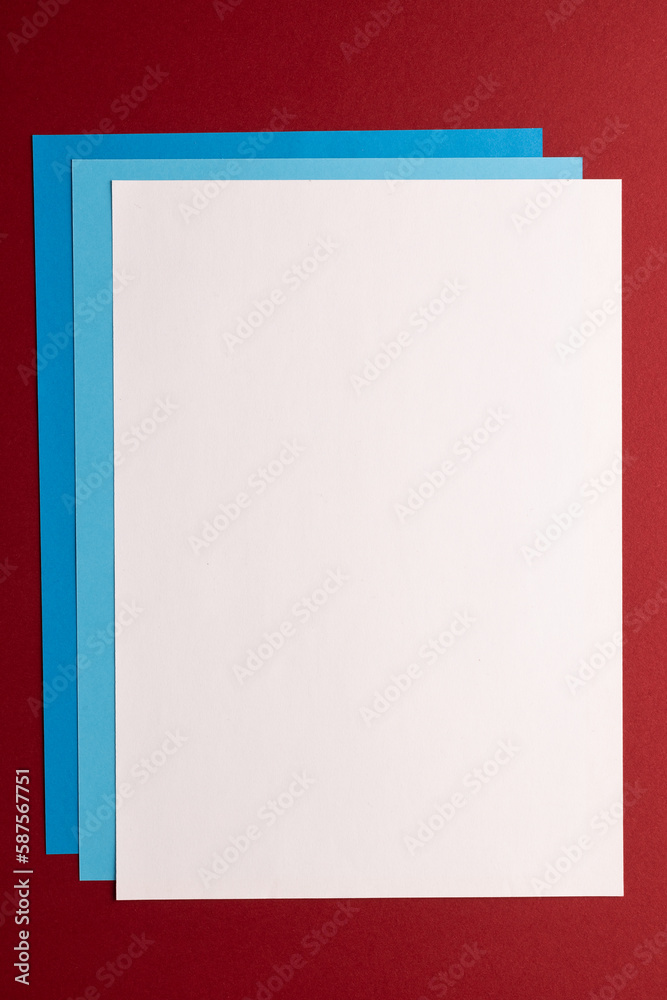 Close up of white and blue paper on red background with copy space Close up of white and blue paper on red background with copy space