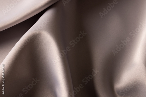 Close up of plain grey satin fabric with folds, copy space