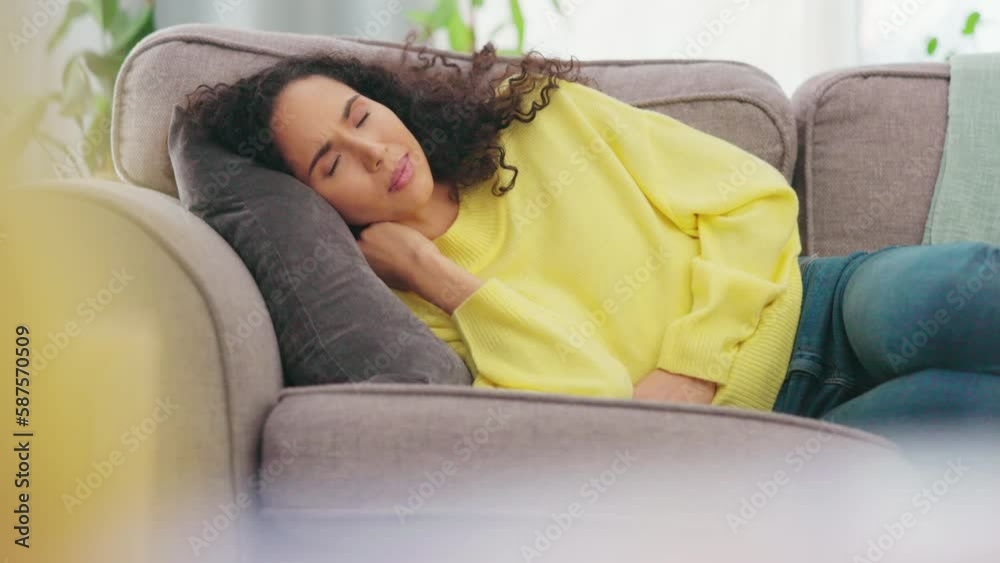 Stomach, pain and woman on a sofa with digestion, problem or suffering from pms. Tummy, virus and sick female with constipation, bloated or endometriosis in living room, unhappy from menstrual cramps Stomach, pain and woman on a sofa with digestion, problem or suffering from pms. Tummy, virus and sick female with constipation, bloated or endometriosis in living room, unhappy from menstrual cramps