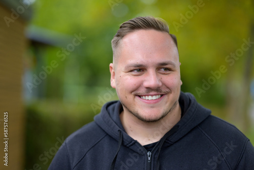 Young man standing in a garden or park