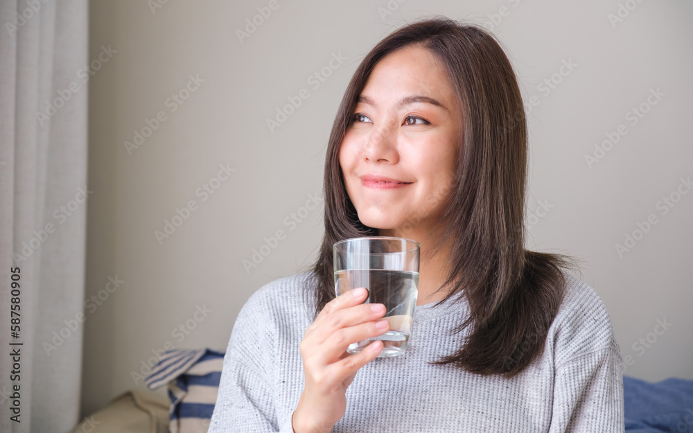Portrait image of a young woman holding and drinking water Portrait image of a young woman holding and drinking water