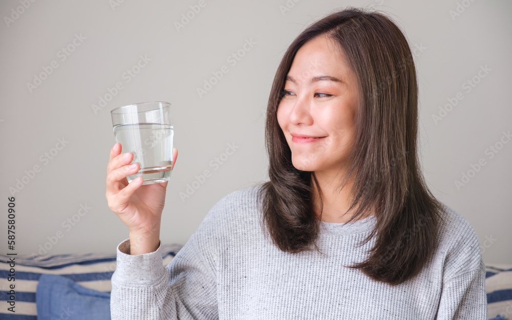 Portrait image of a young woman holding and drinking water Portrait image of a young woman holding and drinking water
