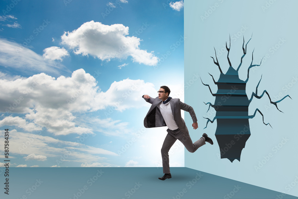 Businessman breaking through the wall Businessman breaking through the wall