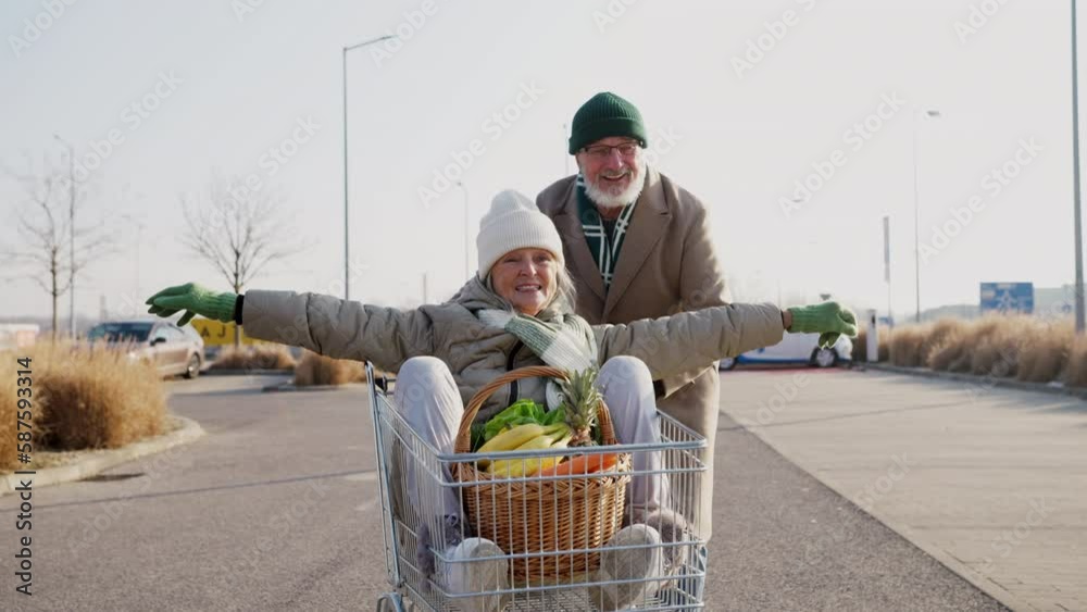 Senior couple going home from grocery store, having fun.