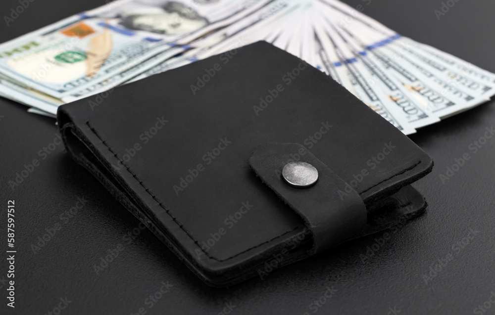 Leather wallet with dollar bills on black. Leather wallet with dollar bills on black.
