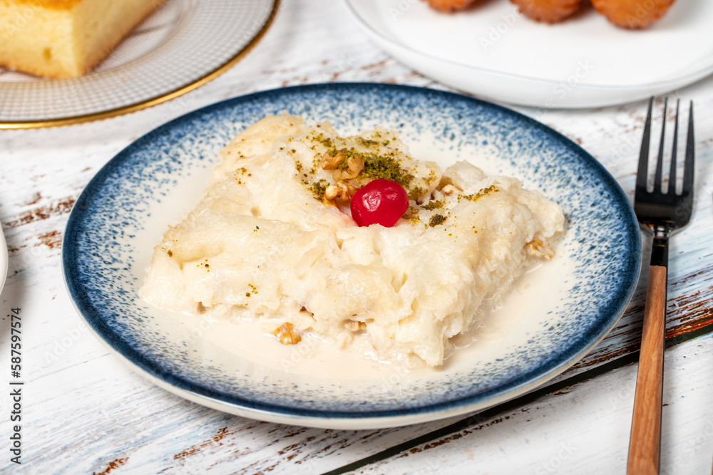 Güllaç, revani, tulumba and bread kadayif dessert with cream on a wood floor. Ramadan sweets. Traditional Turkish cuisine delicacies Güllaç, revani, tulumba and bread kadayif dessert with cream on a wood floor. Ramadan sweets. Traditional Turkish cuisine delicacies