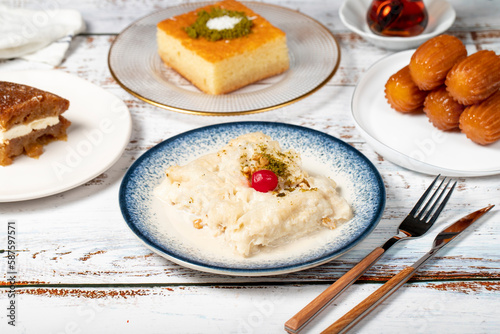 Güllaç, revani, tulumba and bread kadayif dessert with cream on a wood floor. Ramadan sweets. Traditional Turkish cuisine delicacies