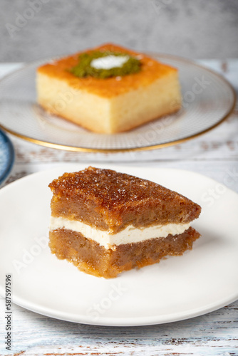 G  lla    revani  tulumba and bread kadayif dessert with cream on a wood floor. Ramadan sweets. Traditional Turkish cuisine delicacies