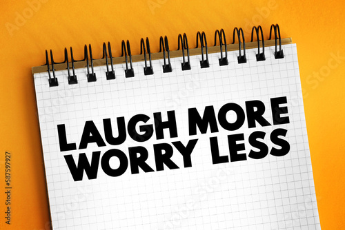 Photo Laugh More Worry Less text on notepad, concept background