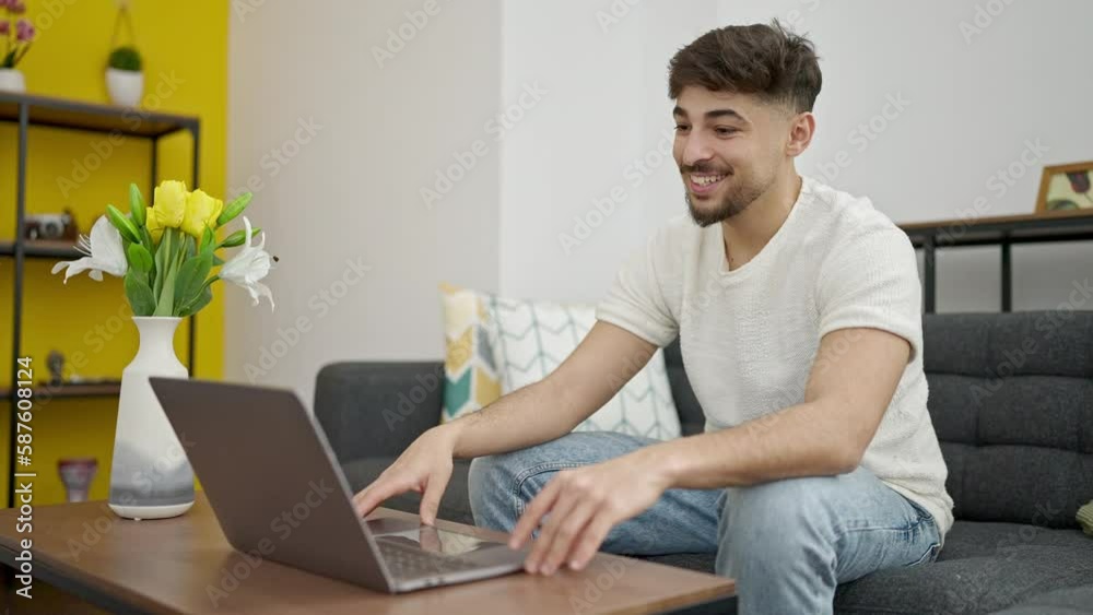 Young arab man having video call sitting on sofa at home Young arab man having video call sitting on sofa at home