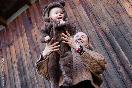 Portrait of young woman holding baby in her hands. mother and son. child happy smiling. © Studio Eli