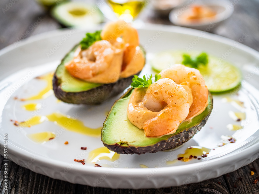 Avocado with fried prawns on and cocktail sauce on wooden background
Avocado with fried prawns on and cocktail sauce on wooden background
