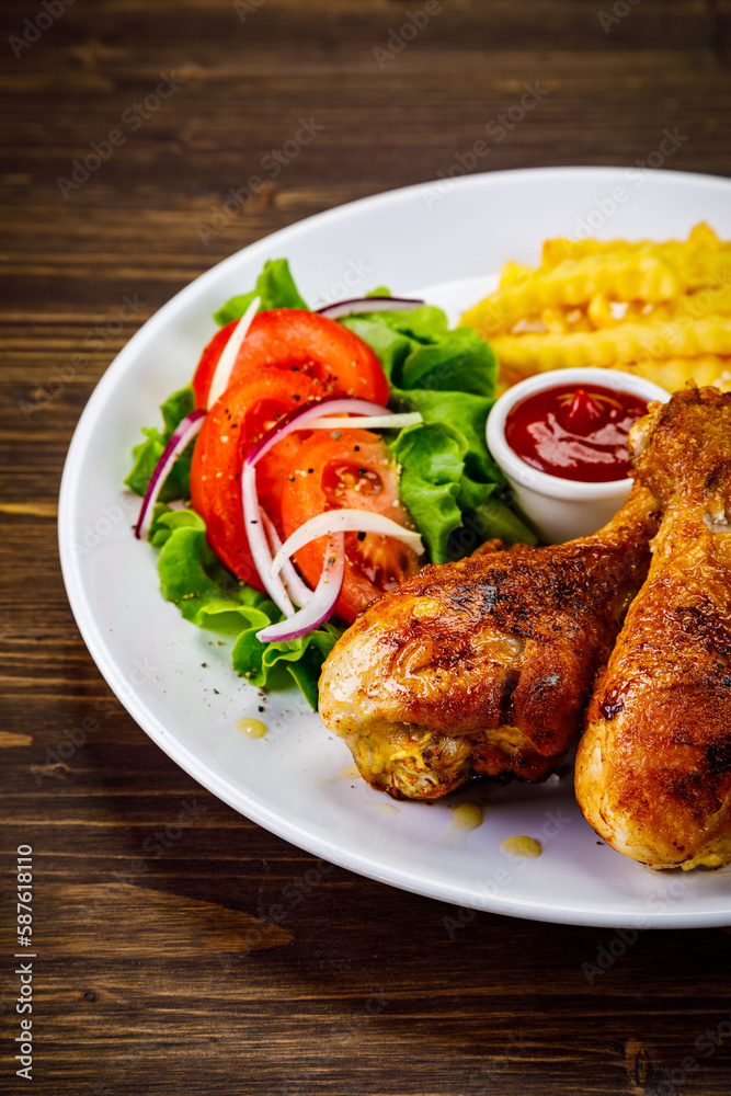 Barbecue chicken drumsticks with French fries, lettuce, tomatoes and ketchup on wooden table
Barbecue chicken drumsticks with French fries, lettuce, tomatoes and ketchup on wooden table