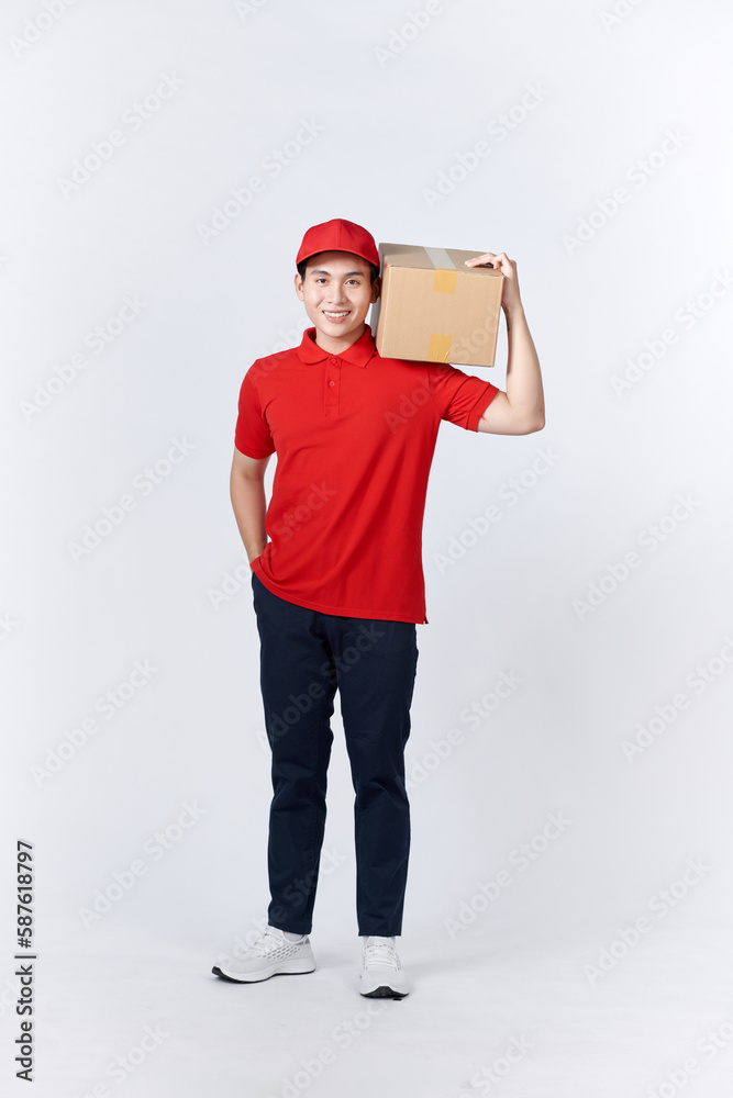 Asian delivery man or passenger holding a cardboard box ready to delivery isolated with clipping path and copy space on white background.