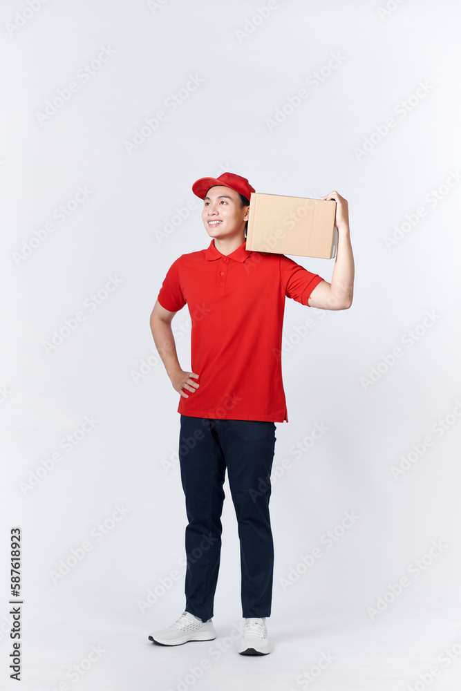 Young man holding delivery package looking positive and happy standing and smiling Young man holding delivery package looking positive and happy standing and smiling