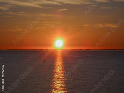 Breathtaking sunrise sunset dusk dawn twilight scenery over ocean with silhouettes of people and boats yachts seen panoramic view from cruiseship cruise ship liner during Caribbean cruising © Tamme