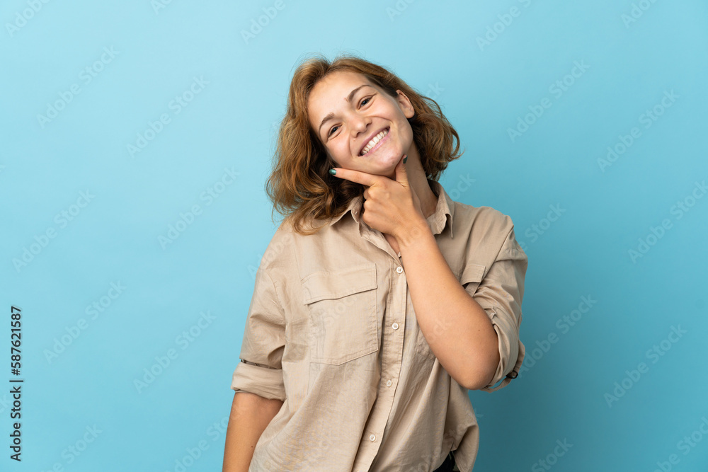 Young Georgian woman isolated on blue background smiling Young Georgian woman isolated on blue background smiling