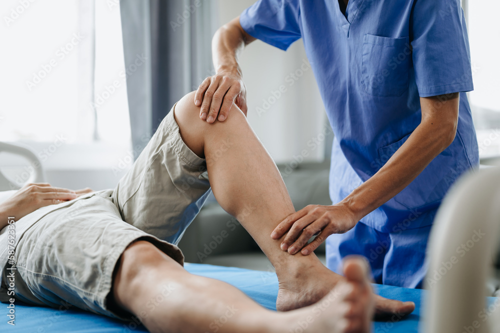 Close up of Physiotherapist working with patient on the bed.