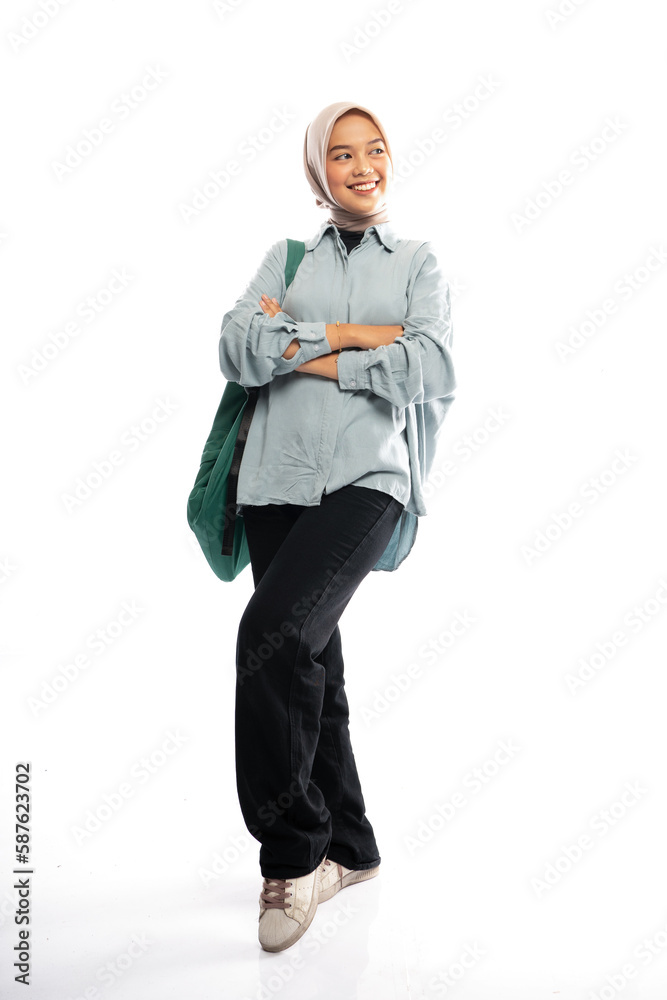 Fototapeta premium Asian Muslim student in hijab standing crossed with backpack on isolated background
