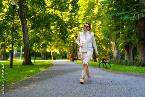 Beautiful woman walking in city park 