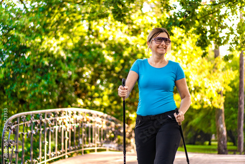 Nordic walking - woman training in city park 