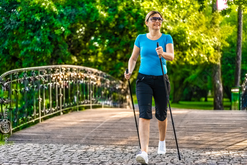 Nordic walking - woman training in city park 