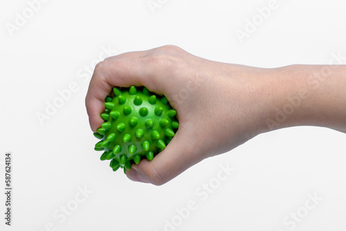 Zgniatanie zielonej piłki rehabilitacyjnej jako ćwiczenie po urazie dłoni 