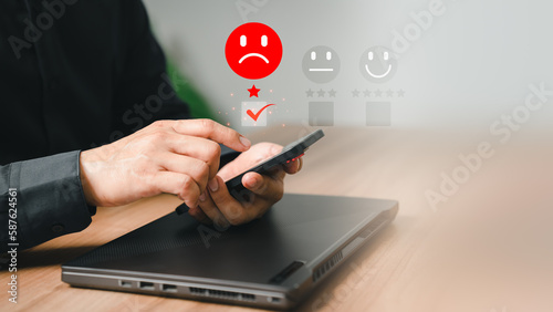Business service concept of customer experience dissatisfied by smartphone. Man client with angry emotion face on virtual screen. Assessment testimonial review for dislike service and low quality.
