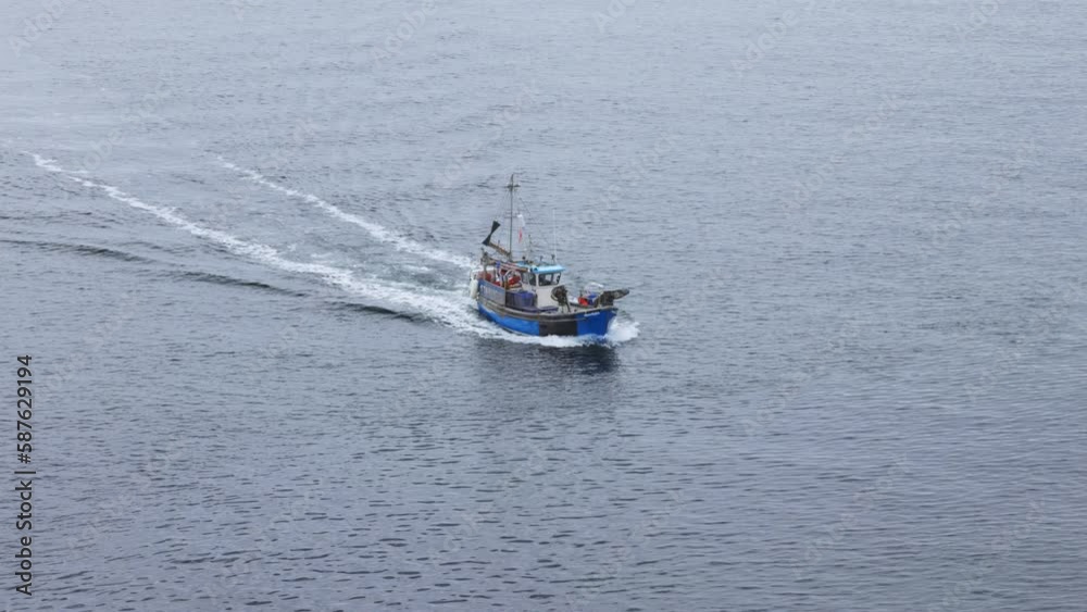 Small Fishing trawler travels across calm grey sea in Cornwall, UK Small Fishing trawler travels across calm grey sea in Cornwall, UK