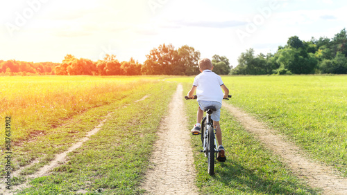 a boy rides a bicycle on a sunny day