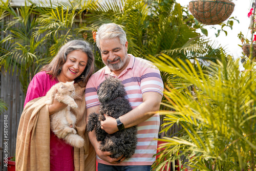 Senior couple playing with dogy puppy and cat. concept of animal love. photo