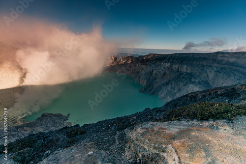 Sunrise over Kawah Ijen Volcano revealing acid turquoise lake and toxic sulfur gases next to illegal mining operation  Java  Indonesia