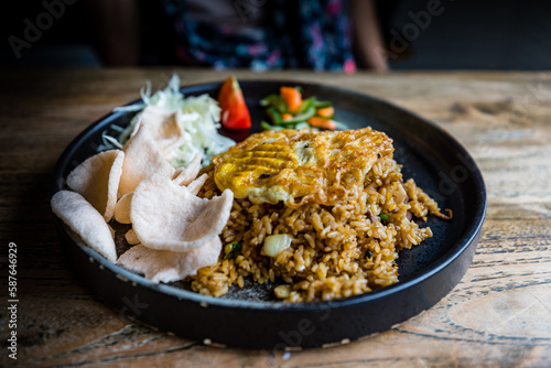 Traditional indonesian cuisine nasi goreng (fried rice) with fried egg, chicken and kerupuk (shrimp crisps), Yogyakarta, Java, Indonesia