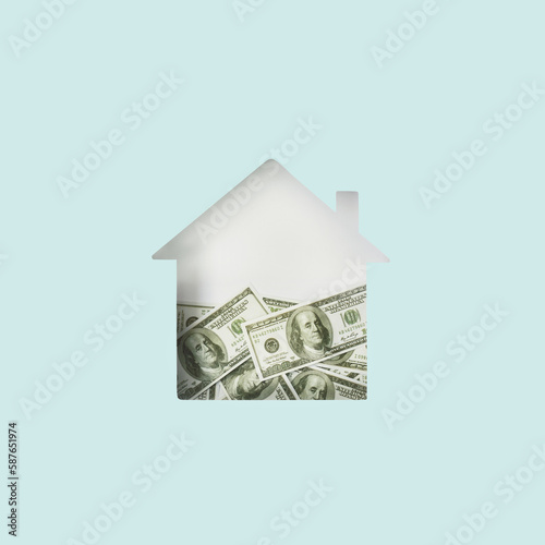 House shape cut out half filled with dollar bills inside. Minimal mortgage, house, savings, insurance concept. Flat lay
