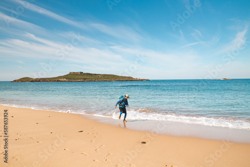 Young  passionate black-haired dobby runs from the waves of the Atlantic Ocean on a sandy beach near Porto Covo  Portugal. In the footsteps of Rota Vicentina