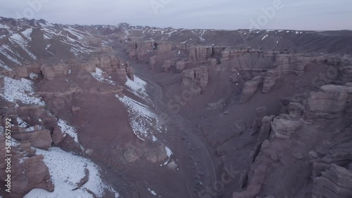 Charyn Grand Canyon with orange rock walls. Aerial view from the drone of the steep canyon walls, cracks and tunnels. There is snow in places. The sun is shining brightly. Brother of the Grand Canyon photo