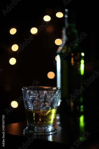 glass of whiskey on black background with lights 