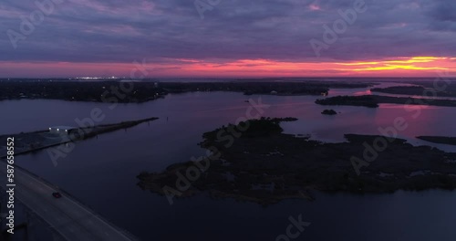 Aerial Backward Shot Of Lake Pontchartrain Causeway Under Pink Clouds During Dusk - New Orleans, Louisiana photo