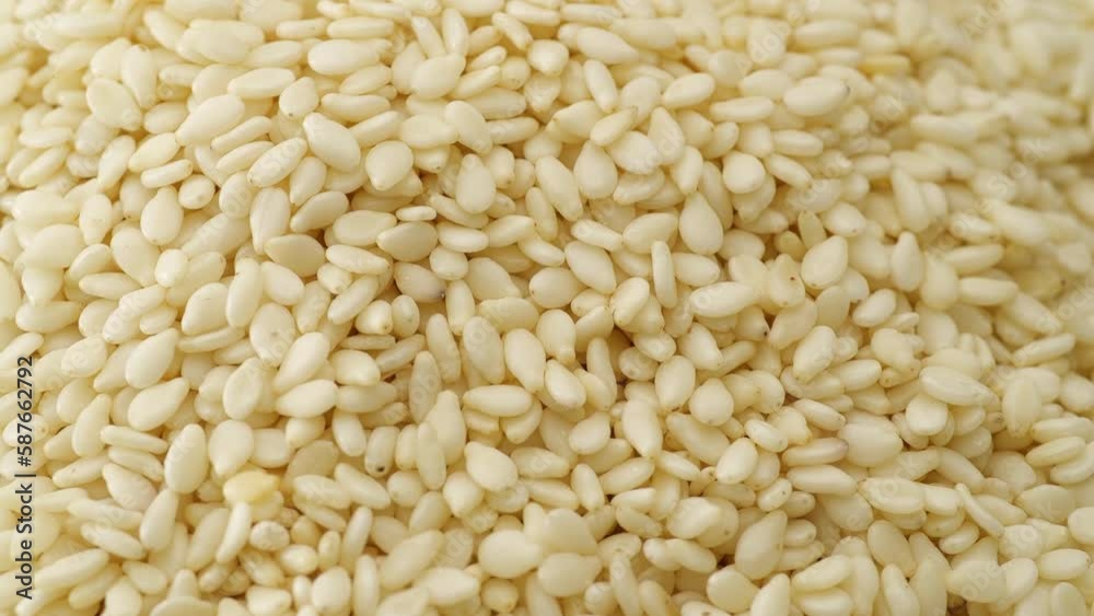Close-up of natural dried white sesame seeds on rotation. Extreme close up. Close-up of natural dried white sesame seeds on rotation. Extreme close up.