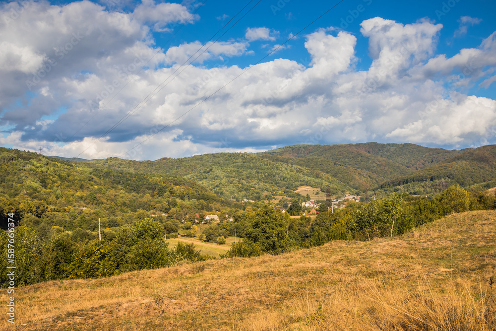 Mountain from view with small village sunny day. Sunny summer morning in the mountains and a small village. Country road in the mountains. Carpathians. Polyana. Ukraine