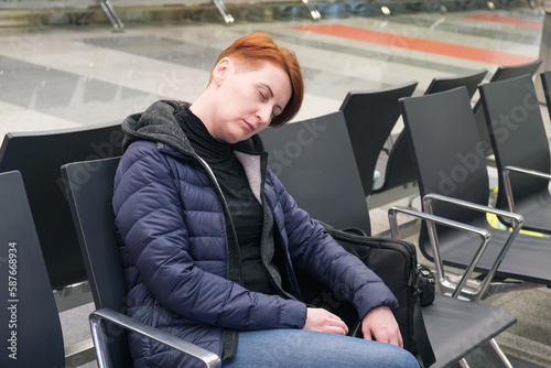Woman sleeps in the departure area of an international airport. The flight passenger overslept the departure time.