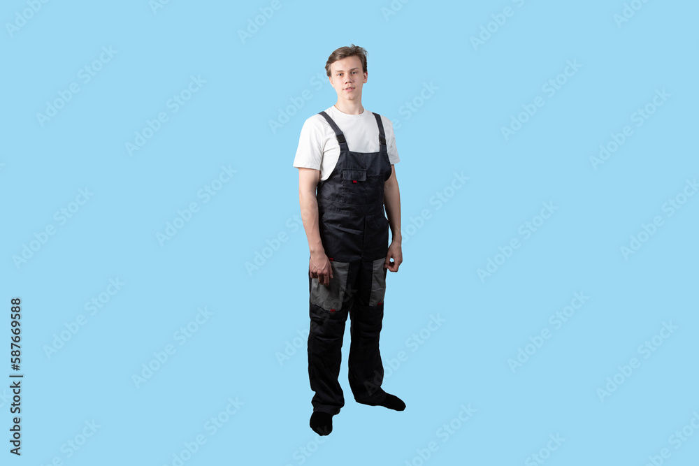 A young man in overalls on a white background.An employee of physical labor. A young man in overalls on a white background.An employee of physical labor.