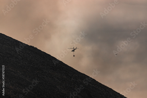 Firefighters helicopter putting out a fire. Arson forest fires in Asturias. Wildfires in Northern Spain