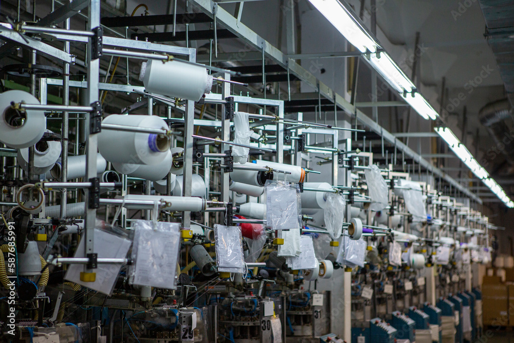 Textile industry with knitting machines in factory. Textile industry with a loom on the production of kapron tights. Textile industry with knitting machines in factory. Textile industry with a loom on the production of kapron tights.