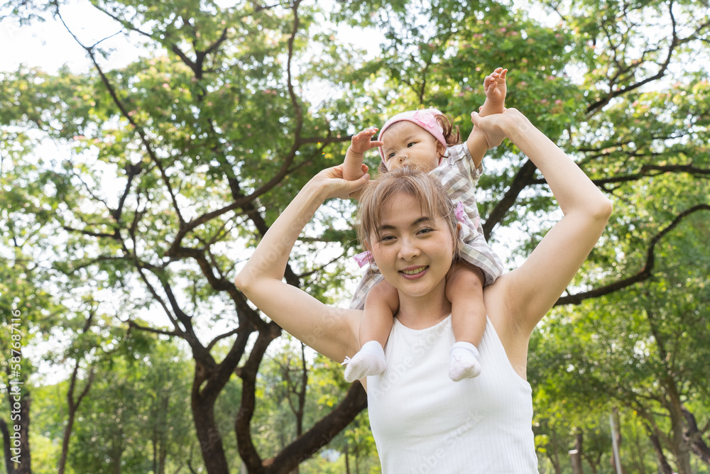 Asian family, Mom and Infant (baby girl) picnicking in city park, happy healthy in the holiday vacation summer. Asian family, Mom and Infant (baby girl) picnicking in city park, happy healthy in the holiday vacation summer.
