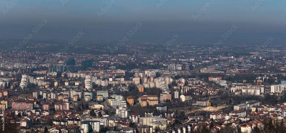 Panoramic view of Banja Luka city during sunny day, air pollution in city, distant hills fade in haze