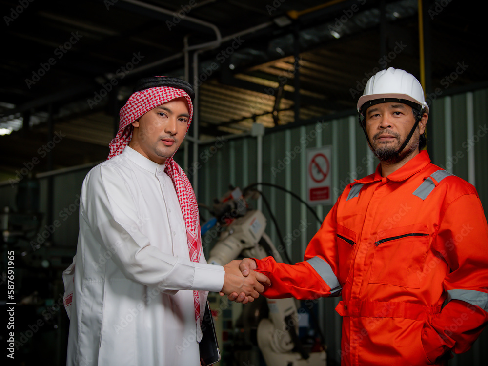 Cyber communication and robotic trend , Industrial 4.0 Cyber Physical Systems technology concept. Double exposure of business men handshake teamwork , welding automate robot arm in smart factory Cyber communication and robotic trend , Industrial 4.0 Cyber Physical Systems technology concept. Double exposure of business men handshake teamwork , welding automate robot arm in smart factory