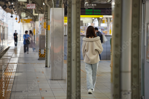 Wallpaper Mural JR名古屋駅のホームで歩く若い女性乗客の後ろ姿と電車の風景 Torontodigital.ca