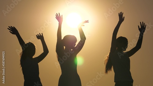 Dancing girls on beach in sun, slow motion, a group of friends from different races, hanging out. Friends out, young healthy woman dancing, enjoying event at sunset, having fun at weekend celebration.
